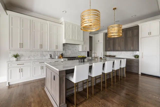 a kitchen with cabinets a island and chairs in it