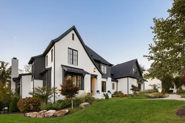 a front view of a house with a yard and trees