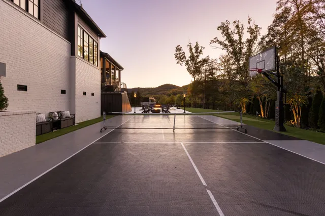 an aerial view of a house with outdoor space and trees all around