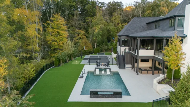 an aerial view of a house with swimming pool and patio
