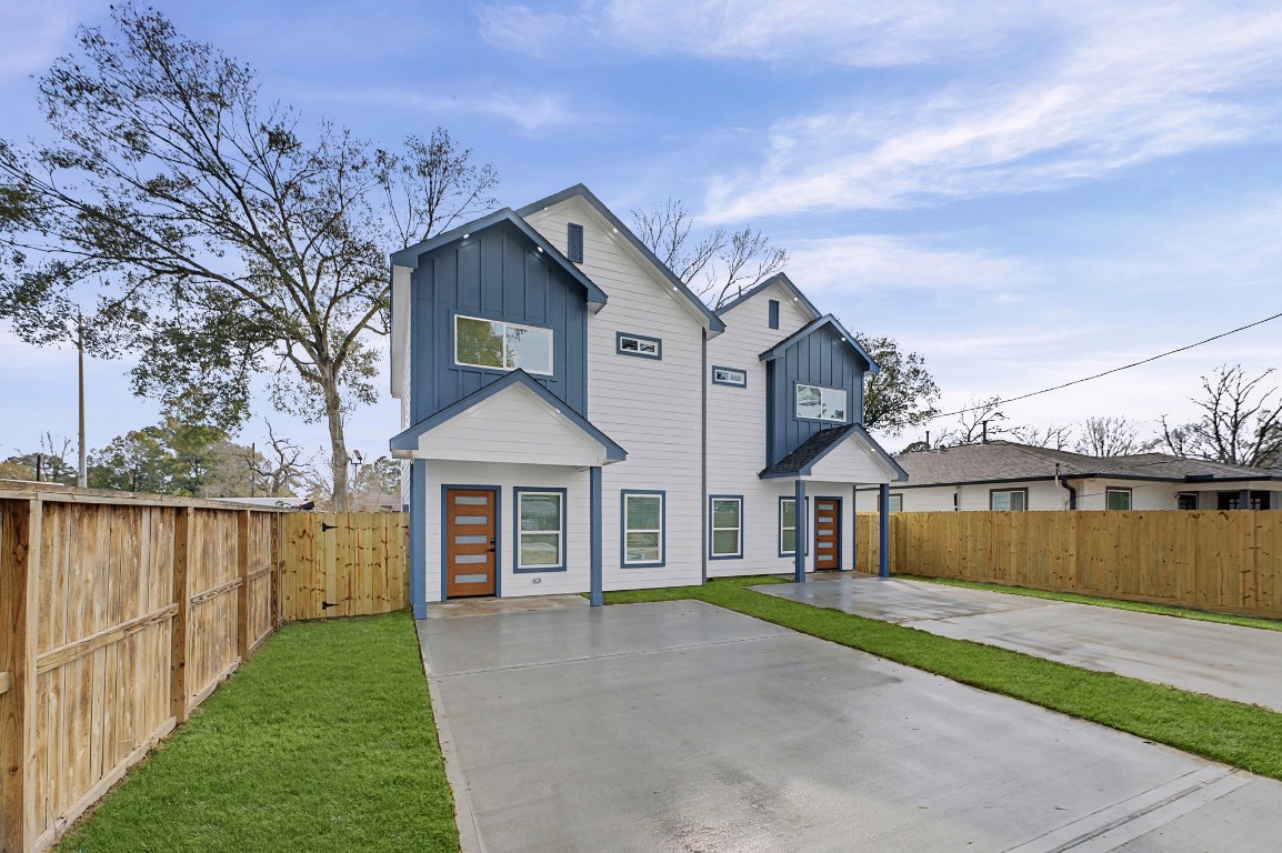 a front view of a house with a garden and lake