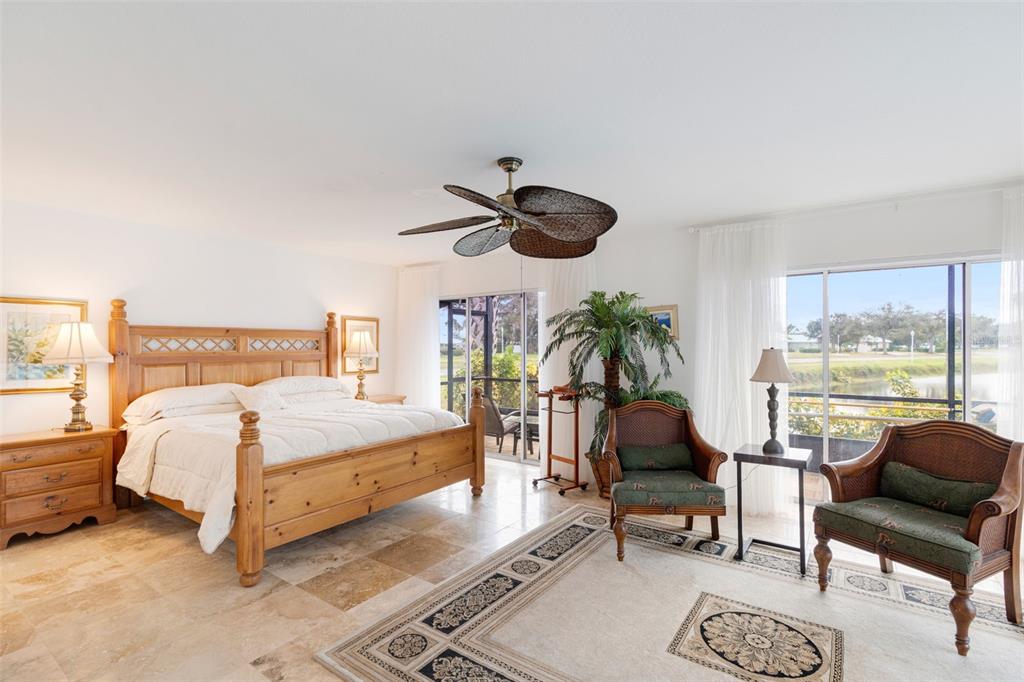 402 Devonshire Lane Venice, FL 34293 - Photo 17 of 52 a spacious bedroom with a bed a couch and a large window