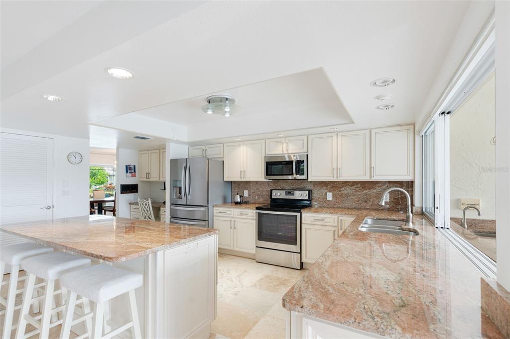402 Devonshire Lane Venice, FL 34293 - Photo 30 of 52 a kitchen with stainless steel appliances granite countertop a sink stove and refrigerator