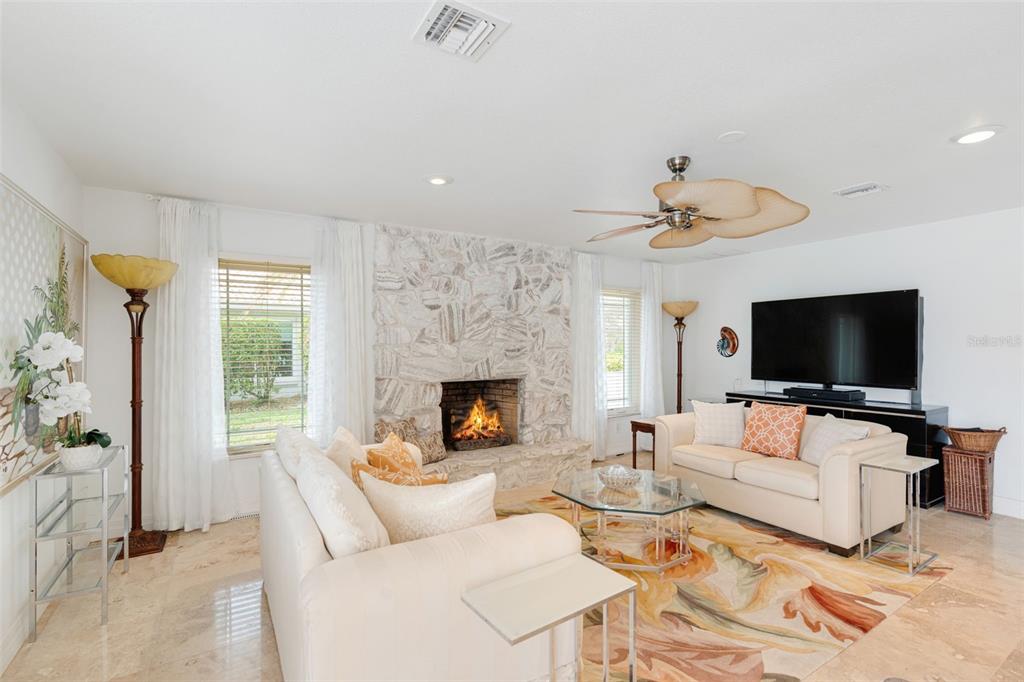 402 Devonshire Lane Venice, FL 34293 - Photo 33 of 52 a living room with furniture a flat screen tv and a fireplace