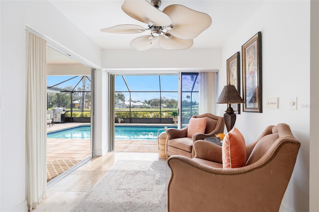 402 Devonshire Lane Venice, FL 34293 - Photo 34 of 52 a living room with furniture and a floor to ceiling window