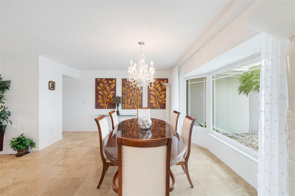 402 Devonshire Lane Venice, FL 34293 - Photo 5 of 52 a dining room with furniture a chandelier and window