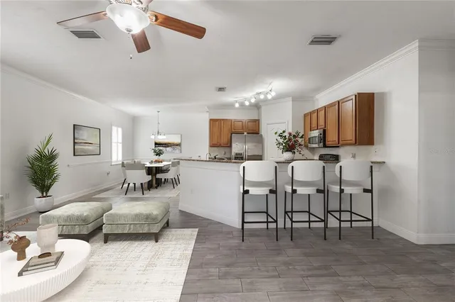 a living room with furniture kitchen view and a wooden floor