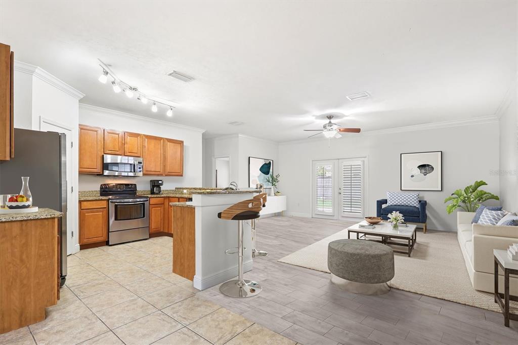 7909 Southwest 87th Terrace Gainesville, FL 32608 - Photo 9 of 17 a kitchen with stainless steel appliances kitchen island granite countertop a refrigerator a sink dishwasher a dining table and chairs with wooden floor