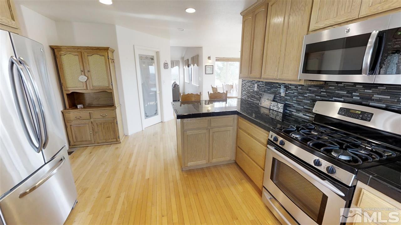 6080 Range Reno, NV 89510 - Photo 4 of 33 a kitchen with stainless steel appliances a stove a sink a microwave and cabinets