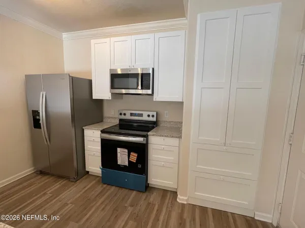 a kitchen with white cabinets and stainless steel appliances
