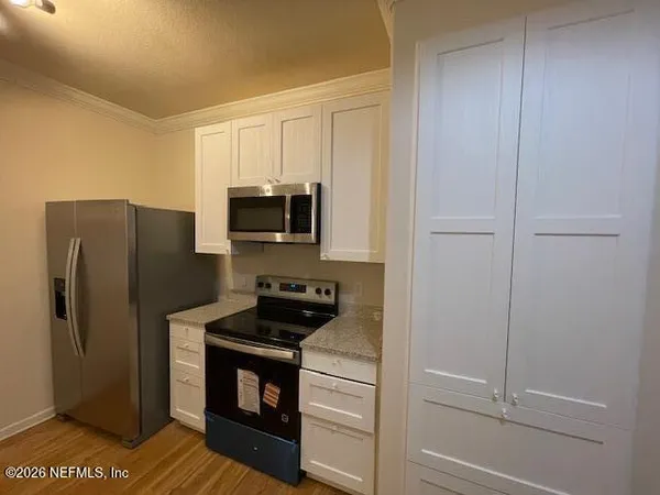 a kitchen with a refrigerator stove and microwave