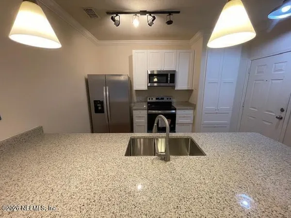 a kitchen with a sink and a refrigerator