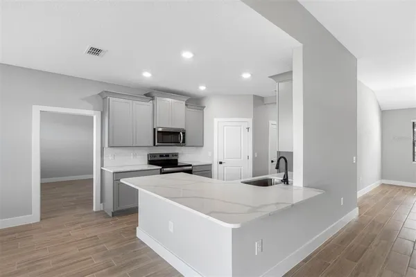 a kitchen with sink a microwave and refrigerator