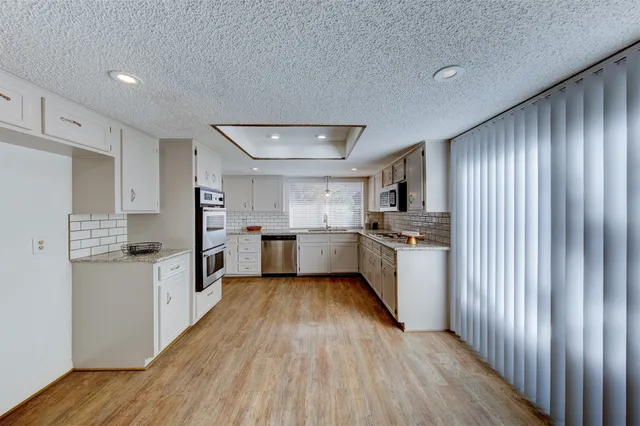 a kitchen with white cabinets and white appliances