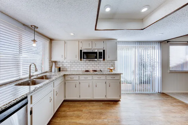 a kitchen with granite countertop a sink stainless steel appliances a counter space and cabinets