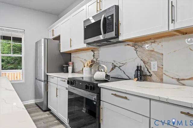 a kitchen with stainless steel appliances granite countertop a sink stove and microwave