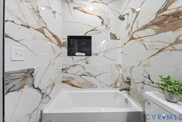 a bathroom with a bathtub and potted plant