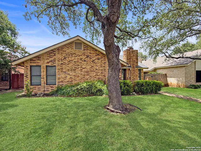 a view of a house with a yard and tree