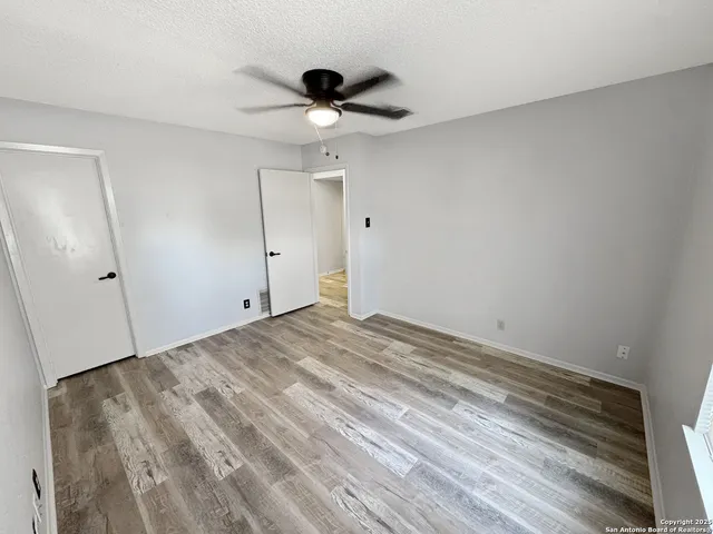 a view of empty room with wooden floor