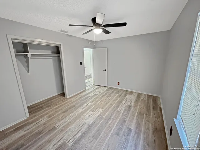 a view of empty room with wooden floor