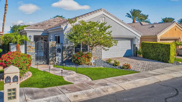 a front view of a house with a yard and potted plants