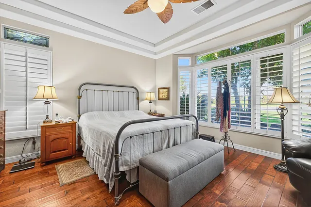 a bedroom with a bed couch and wooden floor