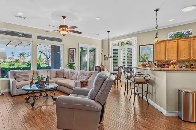 a living room with furniture kitchen view and a large window