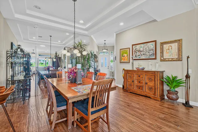 a dining room filled chandelier and wooden floor