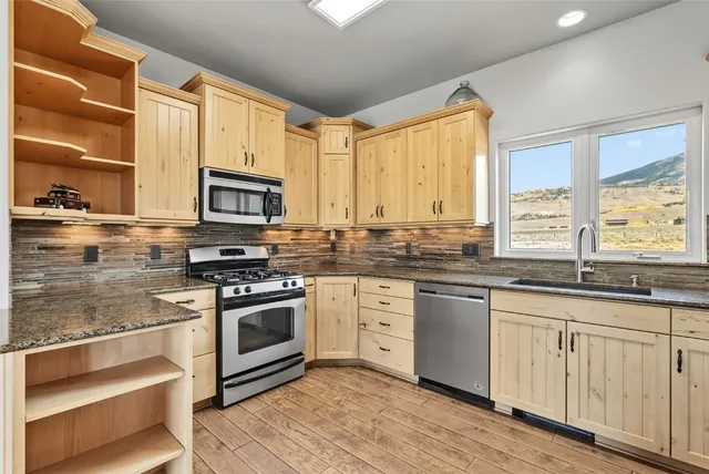 a kitchen with stainless steel appliances granite countertop a stove a sink and a microwave