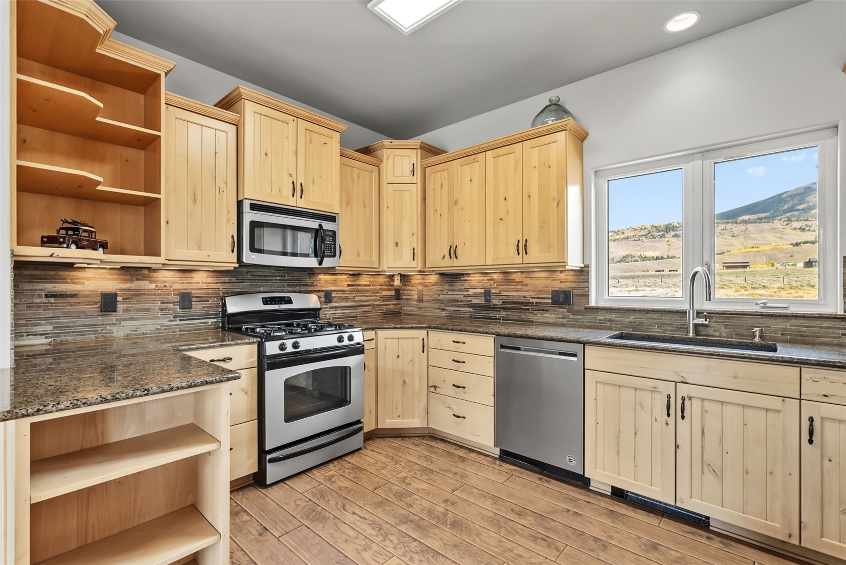 845 Elk Run Road Silverthorne, CO 80498 - Photo 13 of 50 a large kitchen with granite countertop a stove top oven a sink and dishwasher with wooden floor