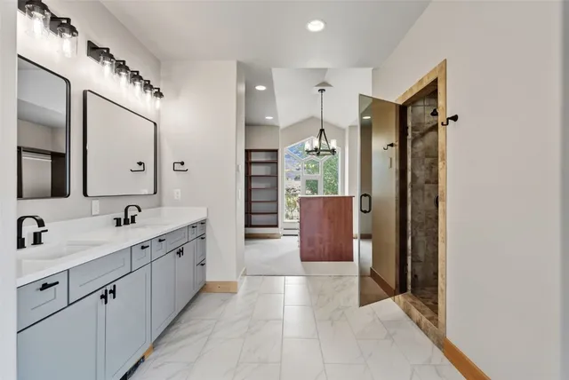 a spacious bathroom with a double vanity sink mirror and shower