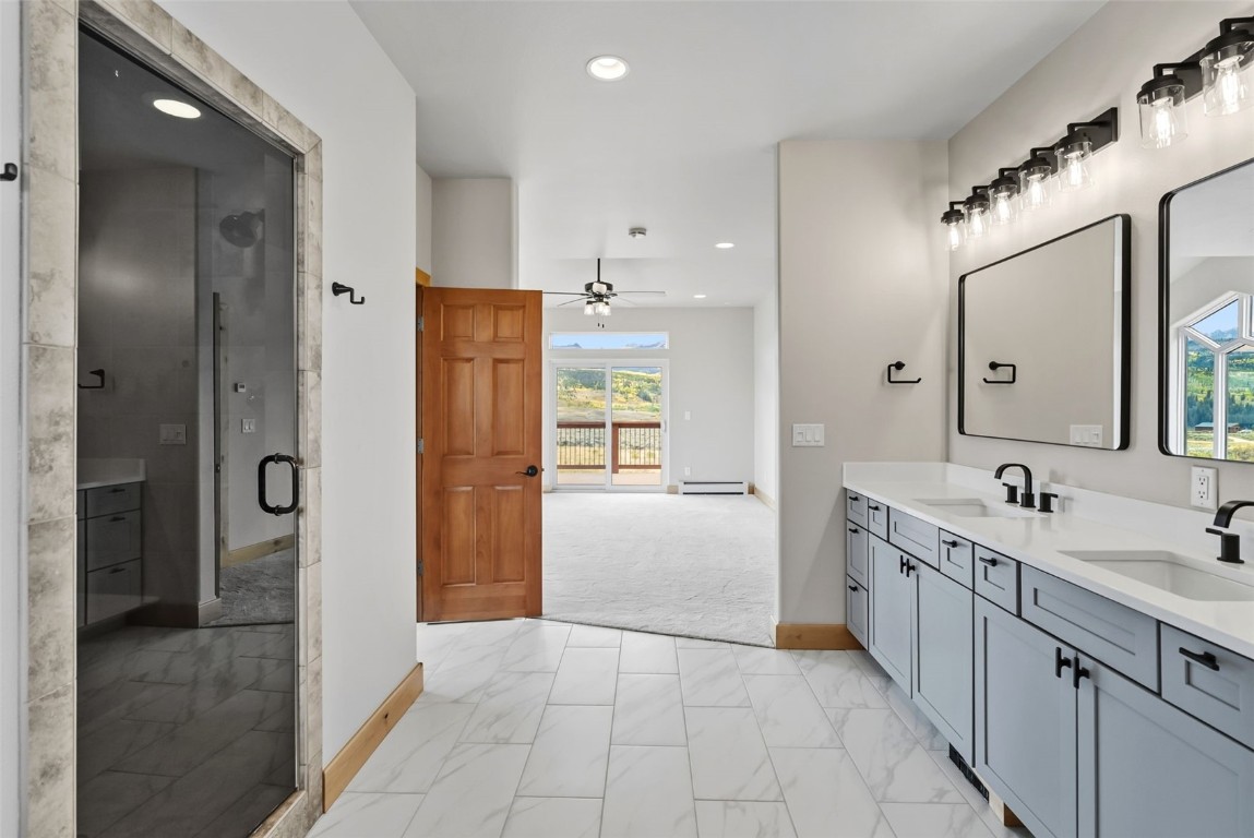 845 Elk Run Road Silverthorne, CO 80498 - Photo 22 of 50 a bathroom with a double vanity sink a large mirror and shower