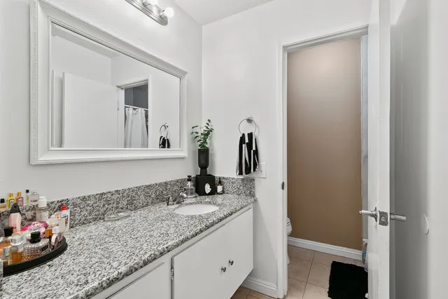 a bathroom with a granite countertop sink and a mirror