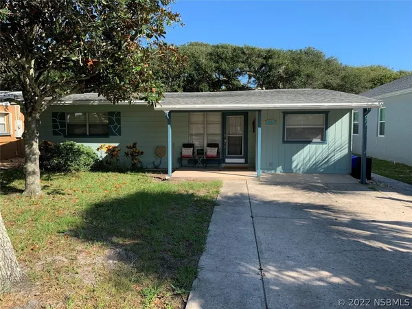 a view of a house with backyard and a tree