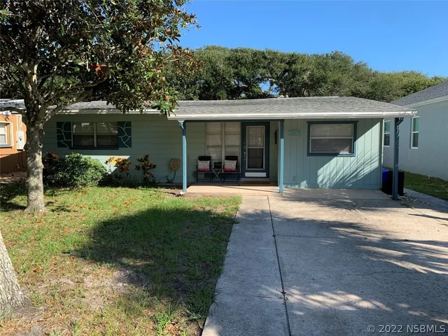a view of a house with backyard and a tree