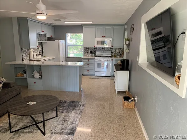 a kitchen with kitchen island a stove a sink and a refrigerator