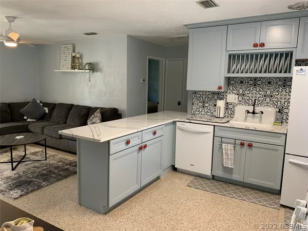 a bed sitting in a bedroom next to a window with wooden floor