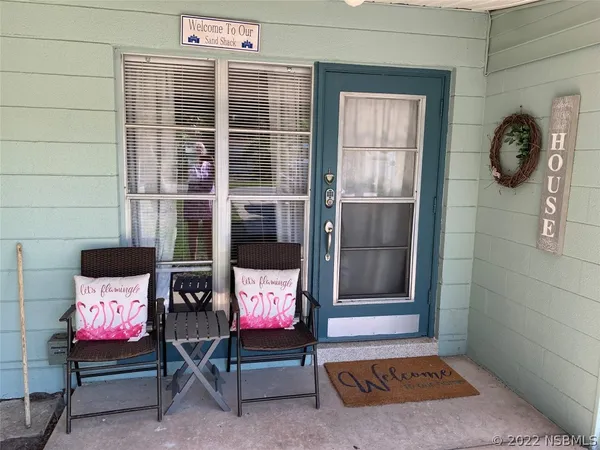a view of a backyard with table and chairs potted plants and a fire pit