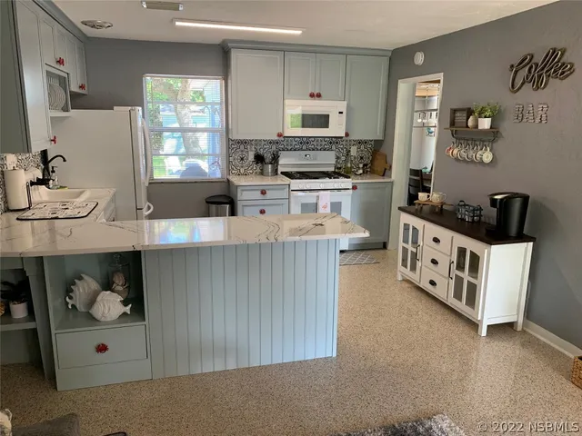 a kitchen with stainless steel appliances kitchen island granite countertop a sink a stove and a refrigerator