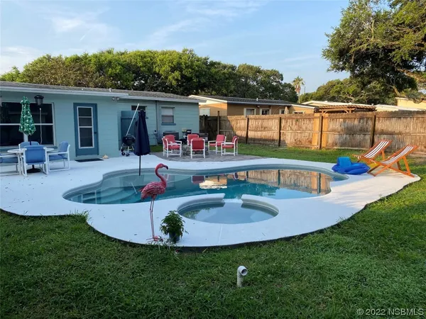 a view of house with backyard and furniture