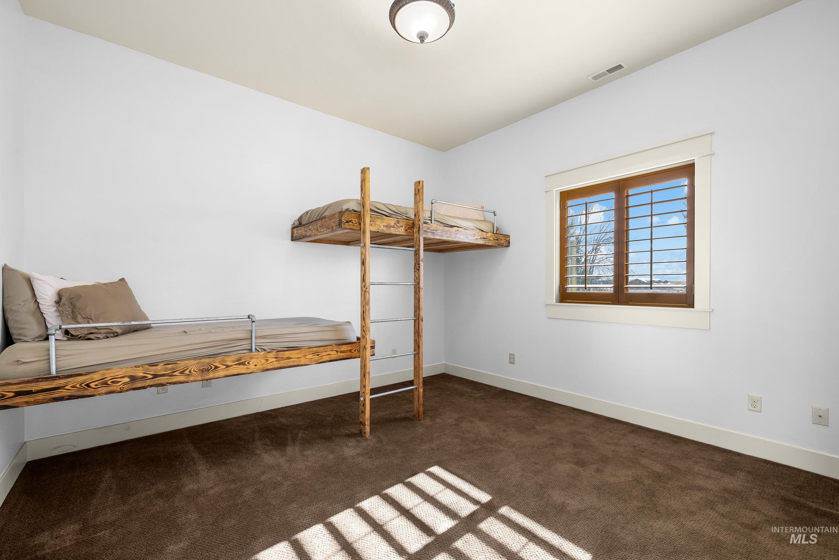 7521 North Grand Ridge Lane Eagle, ID 83616 - Photo 26 of 50 Bedroom featuring dark carpet