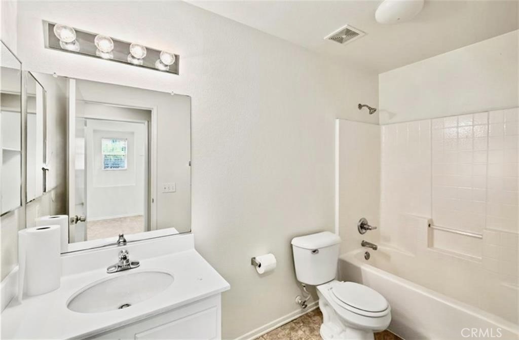 32040 Poppy Way Lake Elsinore, CA 92532 - Photo 14 of 27 a bathroom with a toilet a sink a mirror a shower a vanity and window