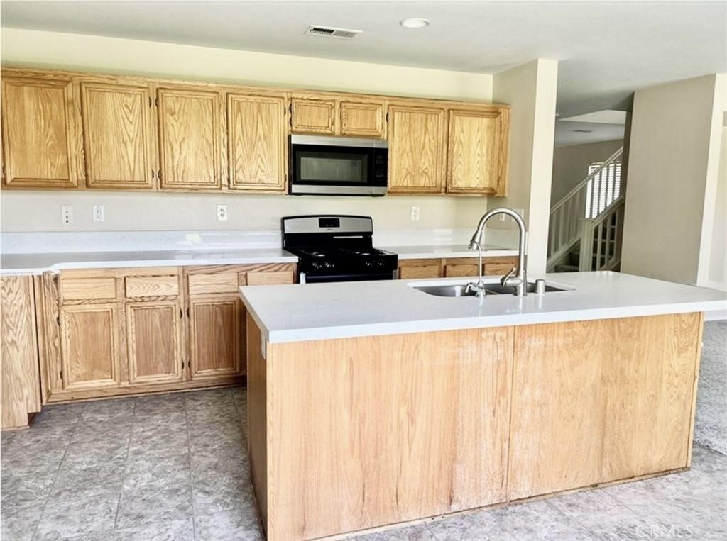 32040 Poppy Way Lake Elsinore, CA 92532 - Photo 5 of 27 a kitchen with a sink a stove and a microwave