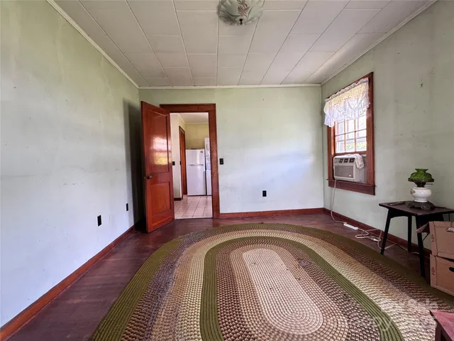 a view of a bedroom with wooden floor and furniture