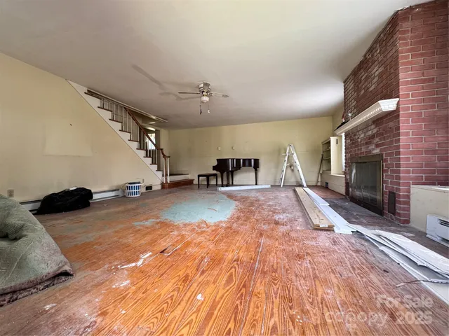 an empty room with windows and ceiling fan
