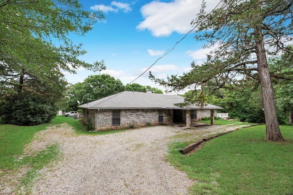 298 Butterfield Road Denison, TX 75021 - Photo 33 of 34 Brick exterior featuring a covered front entry with stone columns and a gravel driveway