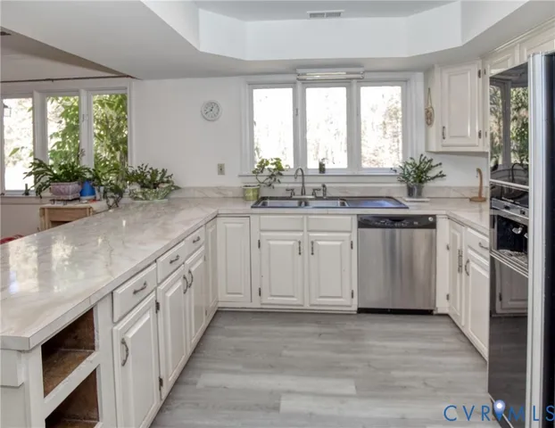 a kitchen with stainless steel appliances a sink stove and cabinets