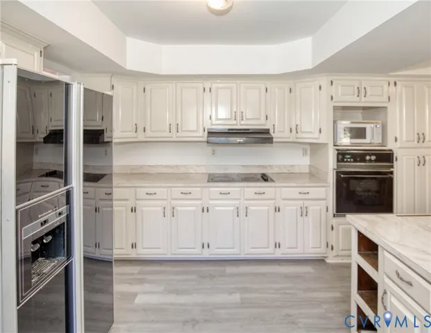 a kitchen with stainless steel appliances granite countertop a refrigerator and cabinets