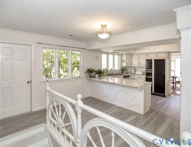 a kitchen with granite countertop white cabinets and stainless steel appliances