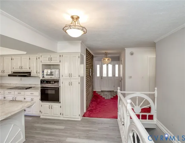 a kitchen with stainless steel appliances granite countertop a stove and white cabinets